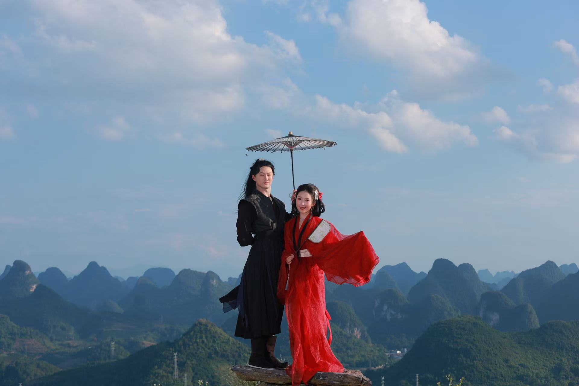 我们在阳朔群山前的合影，手中撑着一把伞